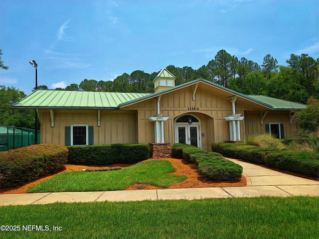 view of front of property with a standing seam roof, metal roof, board and batten siding, and french doors