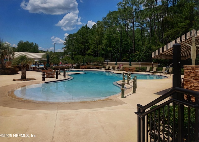 pool with a patio and fence