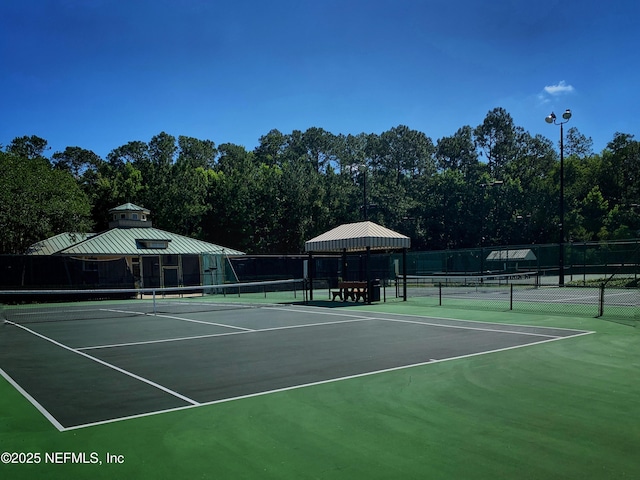 view of tennis court featuring fence