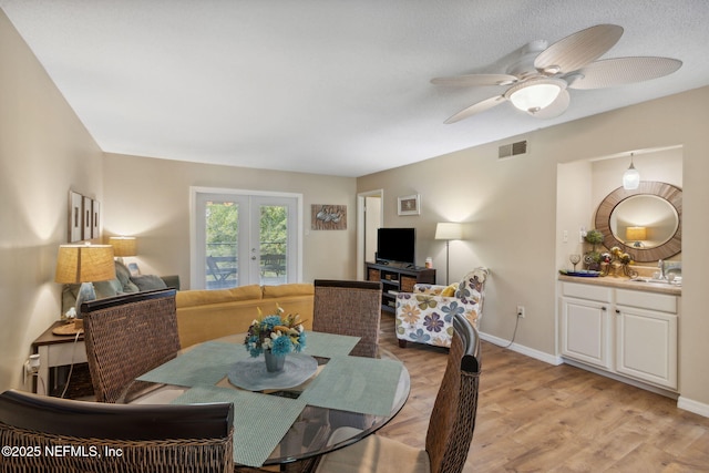 dining area with baseboards, visible vents, a ceiling fan, french doors, and light wood-type flooring