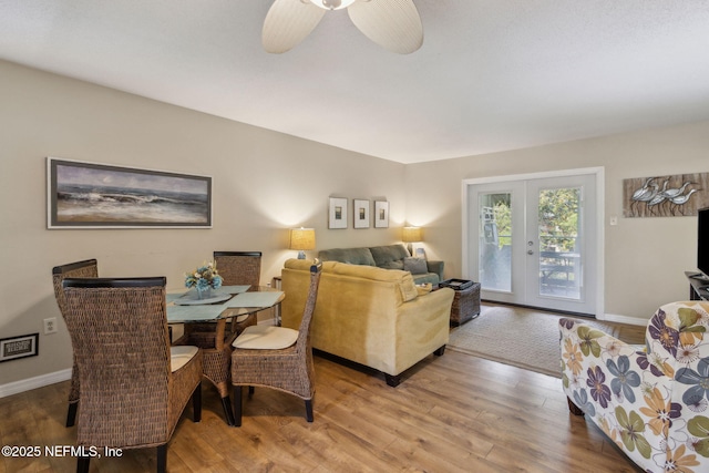 living area with a ceiling fan, baseboards, wood finished floors, and french doors