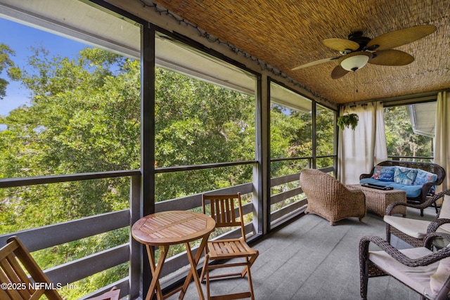 sunroom featuring a ceiling fan and wooden ceiling