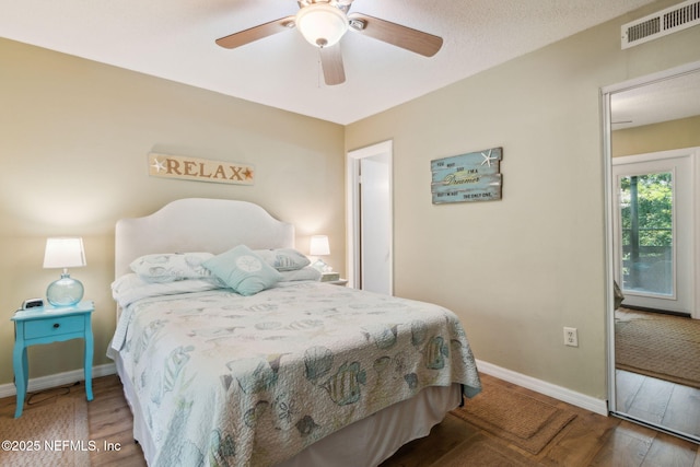 bedroom with a ceiling fan, baseboards, visible vents, and wood finished floors