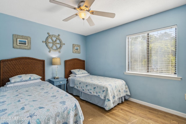 bedroom featuring ceiling fan, baseboards, and wood finished floors