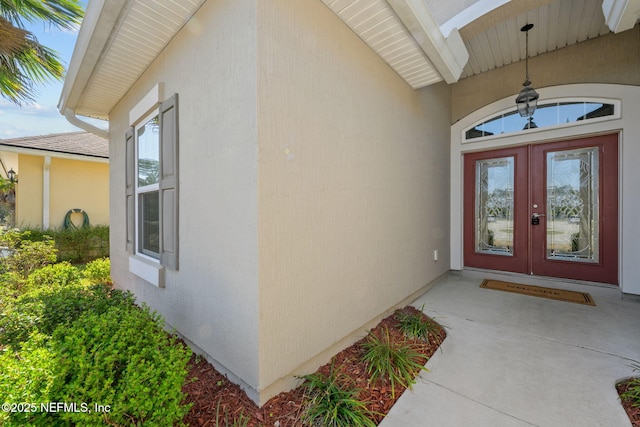 entrance to property featuring french doors and stucco siding