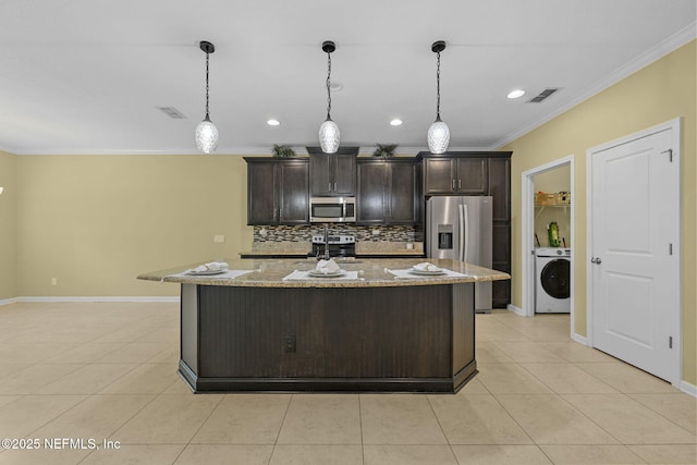 kitchen featuring light tile patterned floors, visible vents, ornamental molding, appliances with stainless steel finishes, and washer / clothes dryer