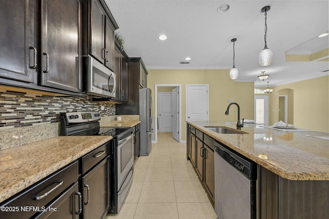 kitchen with arched walkways, ornamental molding, stainless steel appliances, a sink, and light tile patterned flooring