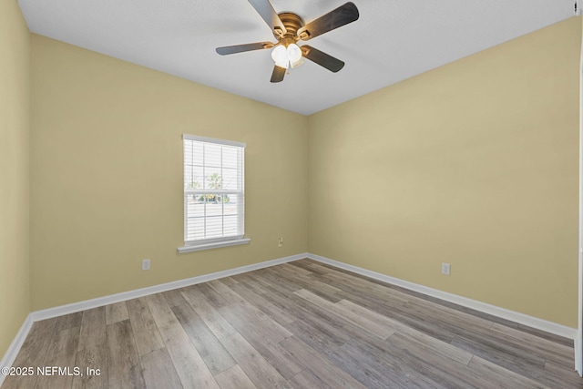 unfurnished room featuring a ceiling fan, baseboards, and wood finished floors