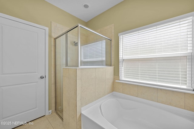 bathroom featuring a garden tub, tile patterned flooring, and a shower stall