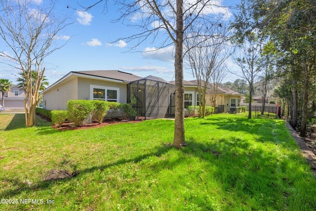 view of front of house featuring stucco siding, a front yard, fence, and a lanai