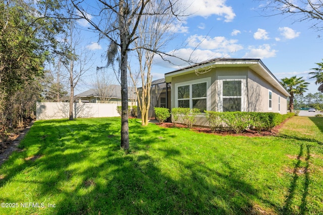 view of yard with a lanai and fence