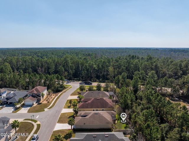 drone / aerial view featuring a forest view and a residential view