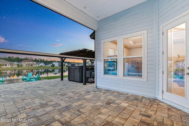 view of patio with a water view, an outdoor fire pit, and fence