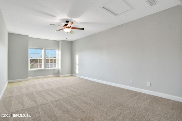 spare room with attic access, visible vents, baseboards, and light colored carpet