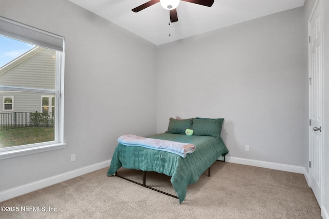 carpeted bedroom featuring baseboards and a ceiling fan