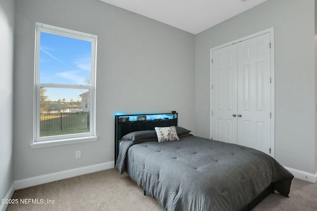 bedroom with a closet, carpet flooring, and baseboards