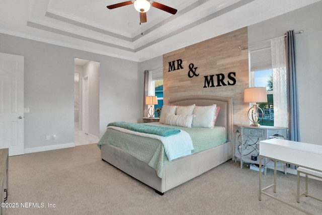 bedroom featuring a tray ceiling, carpet flooring, crown molding, and baseboards