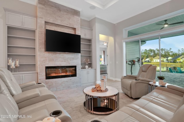 living room featuring baseboards, light wood finished floors, a fireplace, and built in features