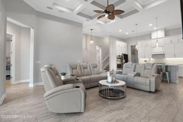 living area with ceiling fan, light wood-type flooring, coffered ceiling, beamed ceiling, and baseboards