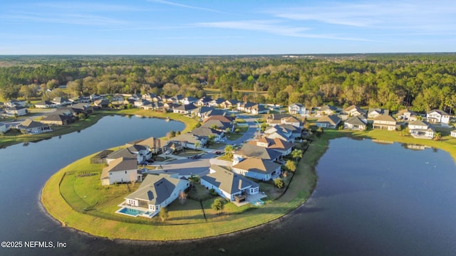 birds eye view of property featuring a water view, a residential view, and a wooded view