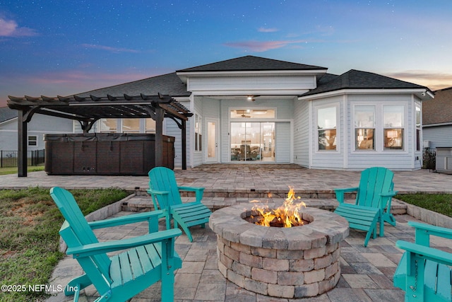 rear view of property with a fire pit, a pergola, and a patio