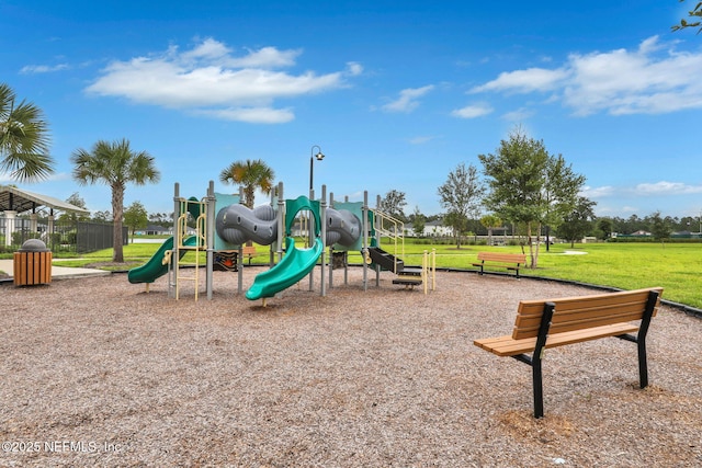 community jungle gym with a lawn and fence