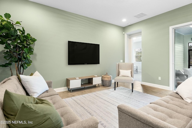 living area with recessed lighting, tile patterned flooring, visible vents, and baseboards