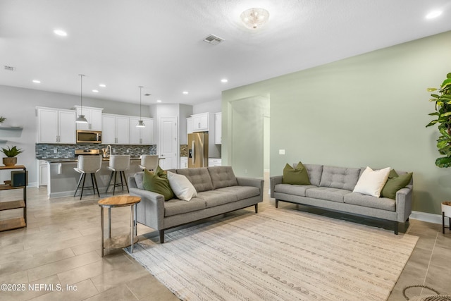 living room featuring recessed lighting, visible vents, baseboards, and light tile patterned floors