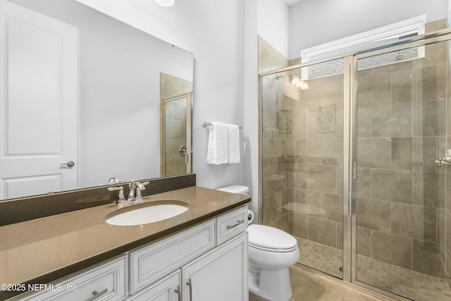 full bathroom featuring toilet, a stall shower, and vanity