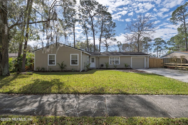 ranch-style home featuring a front lawn, concrete driveway, fence, and an attached garage