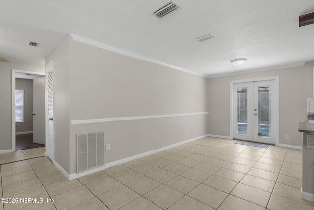 empty room with a wealth of natural light, visible vents, and light tile patterned floors