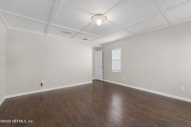 empty room featuring visible vents, baseboards, and wood finished floors