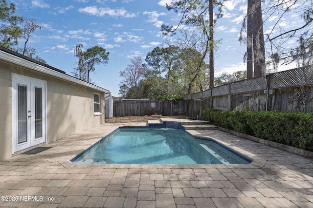 view of pool with a fenced in pool, a patio area, french doors, and a fenced backyard