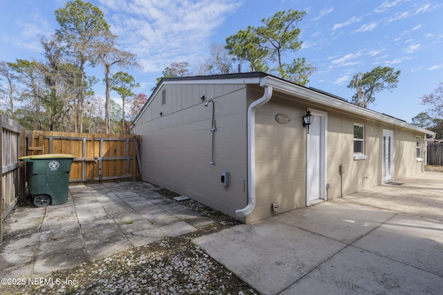 view of side of home featuring a patio and fence