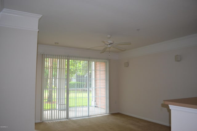 carpeted empty room featuring ceiling fan, ornamental molding, and baseboards