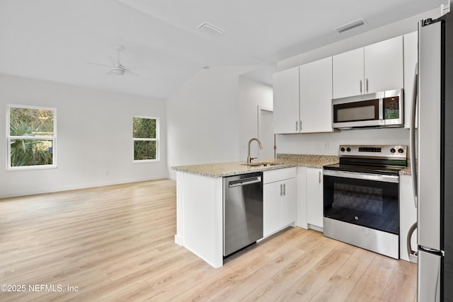 kitchen featuring stainless steel appliances, a peninsula, a sink, and visible vents