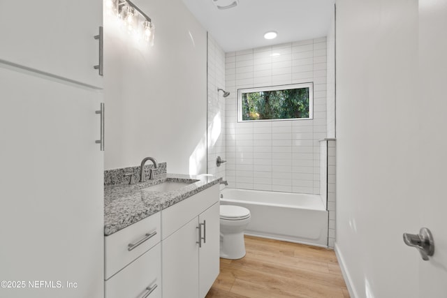 full bathroom featuring baseboards, toilet, shower / tub combination, wood finished floors, and vanity