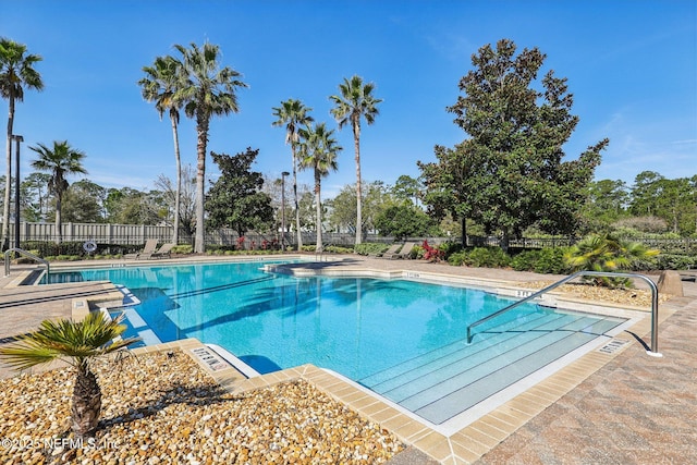 pool with a patio area and fence