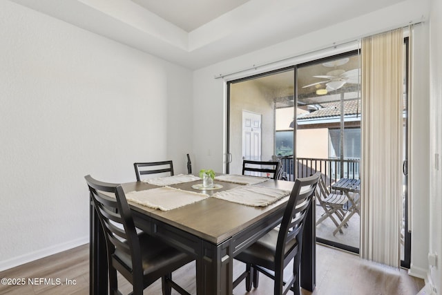 dining area featuring ceiling fan, wood finished floors, and baseboards