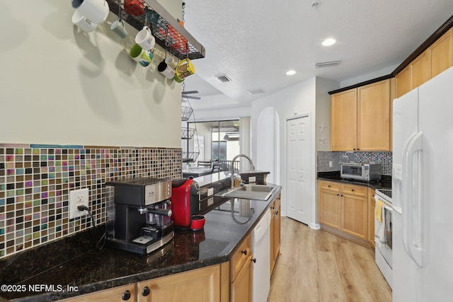 kitchen with arched walkways, visible vents, a sink, light wood-type flooring, and white appliances