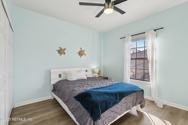 bedroom with wood finished floors, a ceiling fan, and baseboards