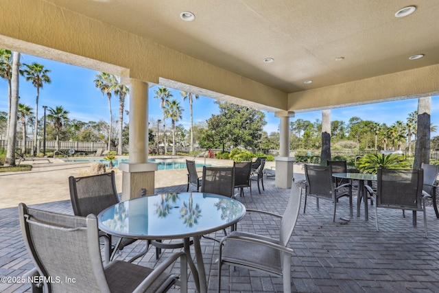 view of patio / terrace featuring outdoor dining space, fence, and a fenced in pool