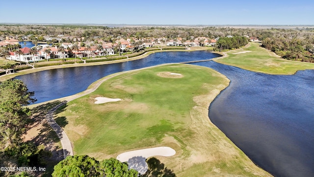 drone / aerial view with view of golf course, a water view, and a residential view