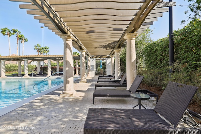 view of patio with a community pool and a pergola