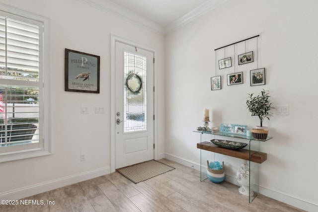 entrance foyer with baseboards, crown molding, and wood finished floors