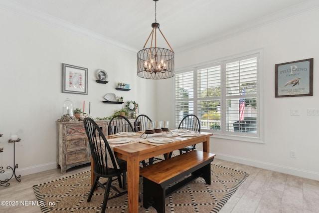 dining space with a notable chandelier, ornamental molding, light wood-style floors, and baseboards