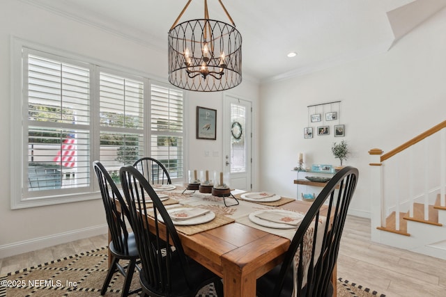 dining space featuring baseboards, ornamental molding, an inviting chandelier, stairs, and light wood-style floors