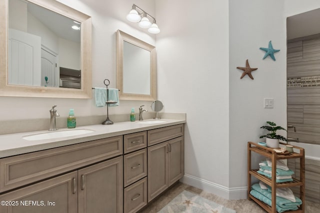 bathroom featuring double vanity, baseboards, and a sink