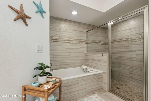 full bath featuring a stall shower and tiled tub