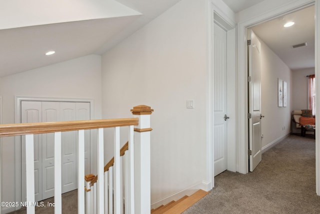 hallway featuring recessed lighting, vaulted ceiling, carpet flooring, and an upstairs landing